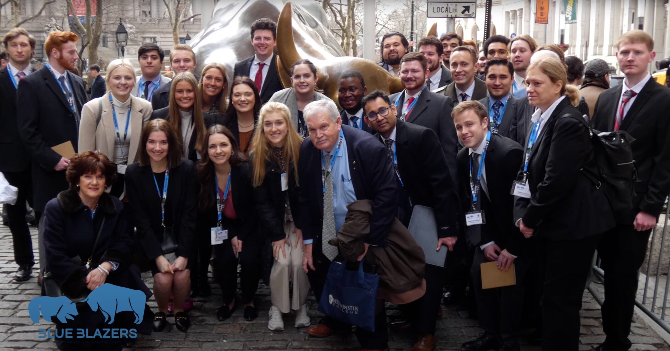 All Blue Blazers members and chaperones from the BBIC 2023 New York Trip pose on Wall Street.