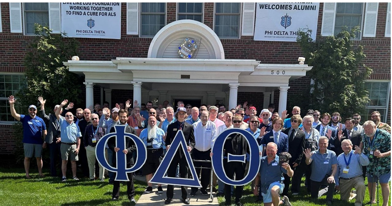 Group photo of Phi Delt men in front of their house.