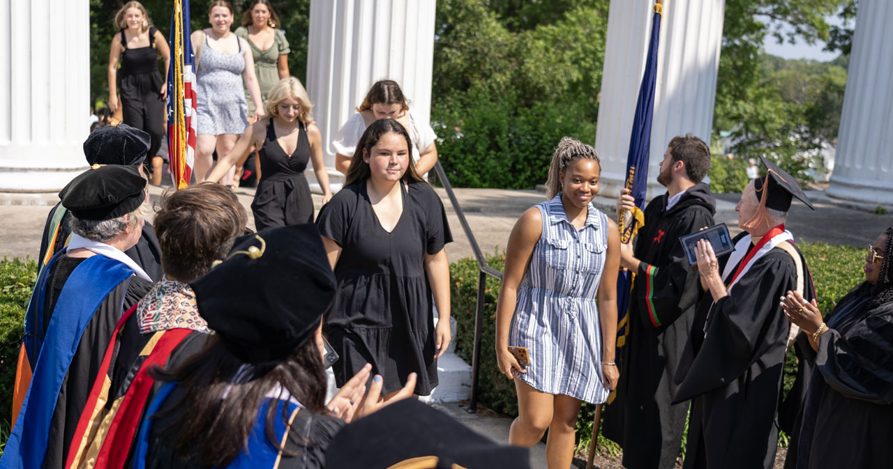Incoming Westminster students pass through the Columns, filing by faculty members in academic regalia.