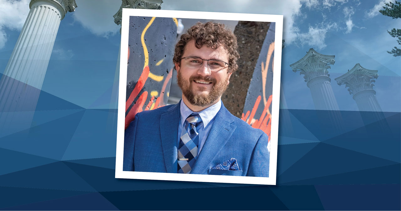 Erich Jauch stands in front of a colorful background, wearing a blue blazer and blue-striped tie. The square photo is placed over a rectangular blue background.