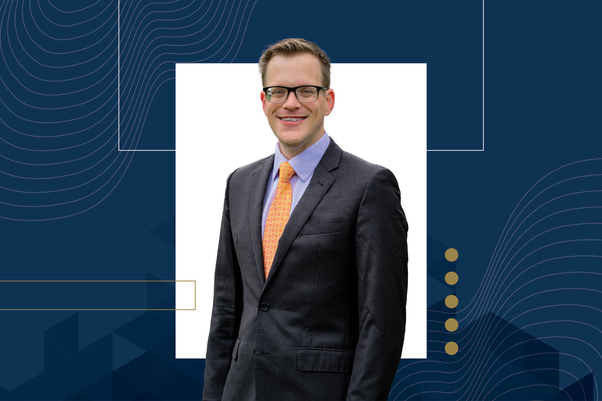 John York is pictured in a dark suit with a bright tie and blue shirt. His photo has a white background, which is placed over a blue rectangle.