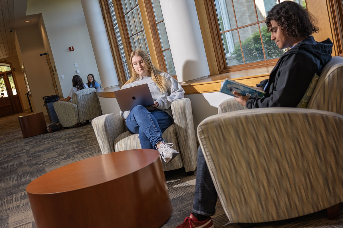 Two students read in comfortable chairs located on Westminster's campus.
